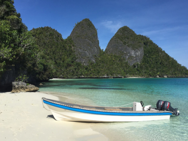 one of Coralia's dive boats at a sandy beach in Raja Ampat Indonesia