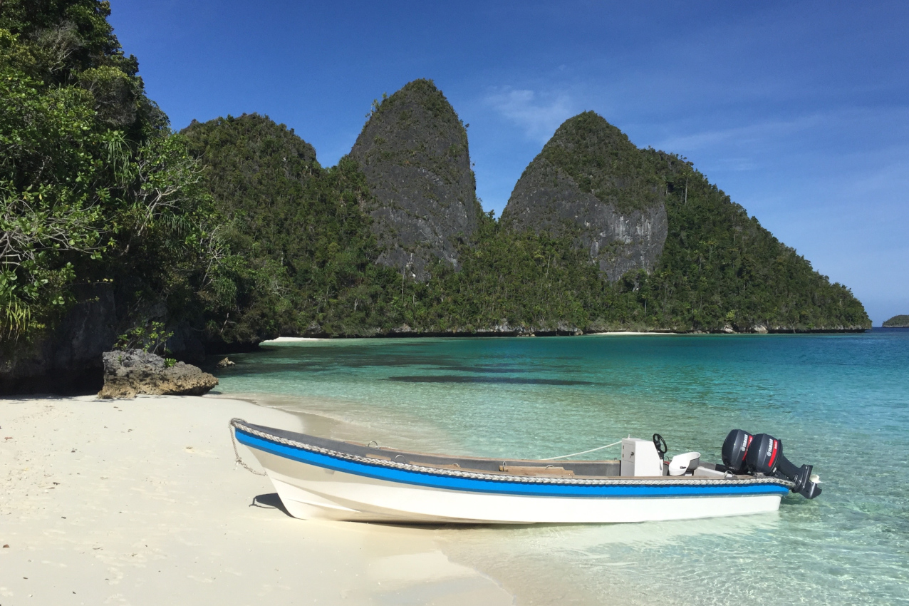 one of Coralia's dive boats at a sandy beach in Raja Ampat Indonesia