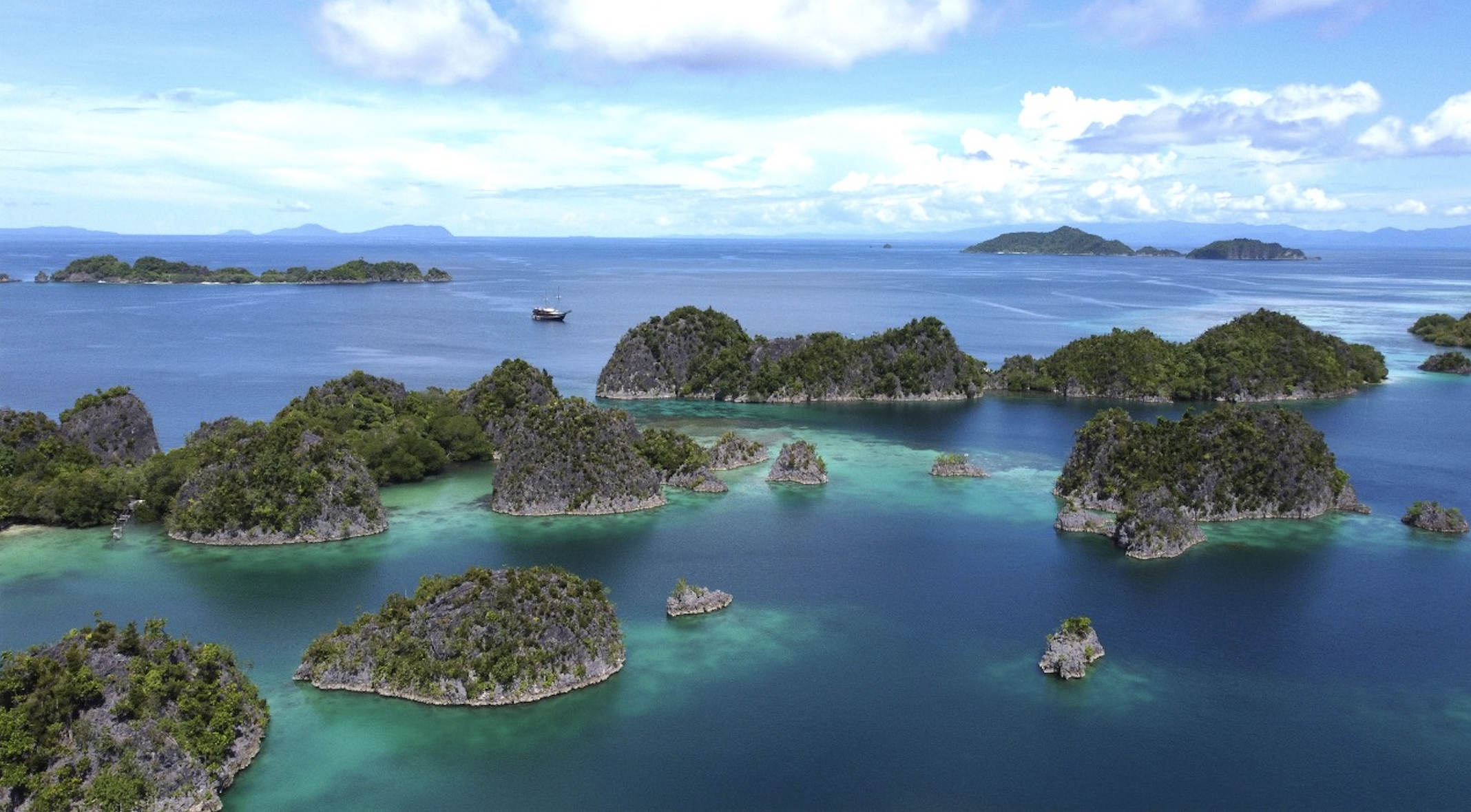 Coralia Liveaboard at Piaynemo viewpoint surrounded by emerald karst islands in Raja Ampat